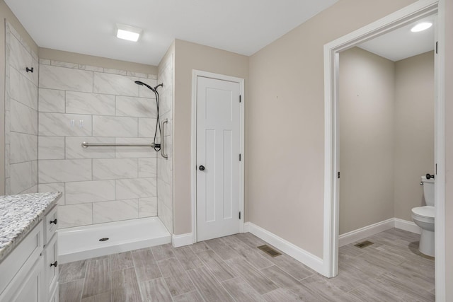 full bath featuring visible vents, tiled shower, and toilet