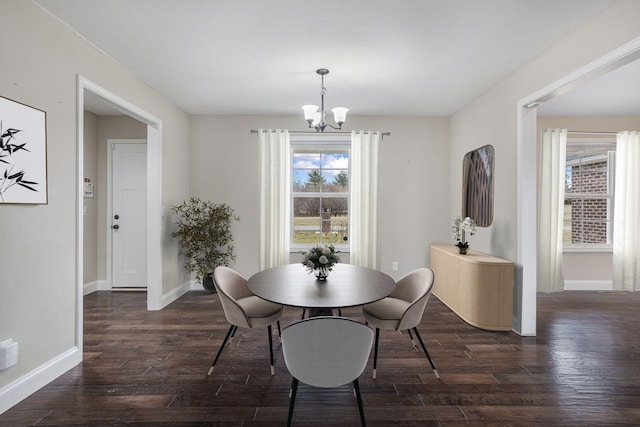 dining area with baseboards, an inviting chandelier, and dark wood-style flooring