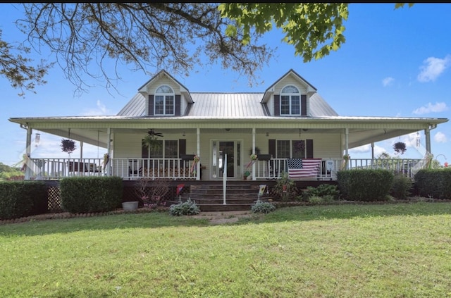 farmhouse-style home with covered porch, metal roof, a front yard, and a ceiling fan