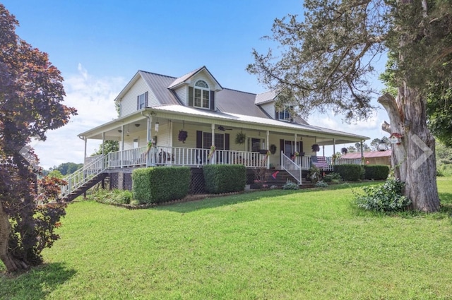 farmhouse-style home with covered porch, metal roof, a front lawn, and stairway