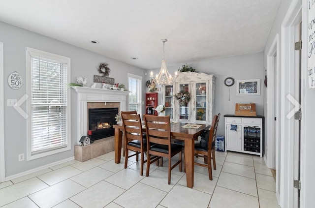 dining room with plenty of natural light, a chandelier, and a tiled fireplace