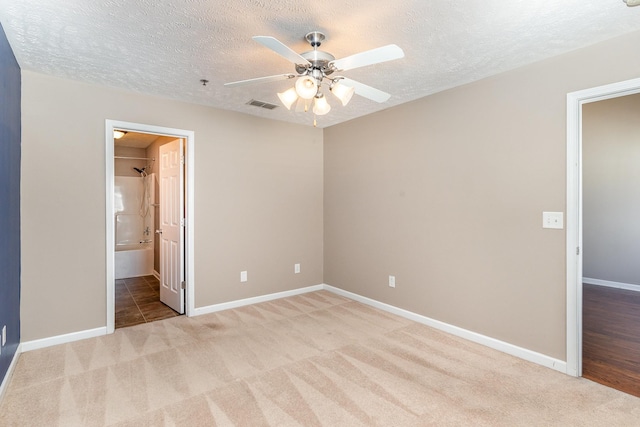 unfurnished bedroom with carpet floors, baseboards, visible vents, and a textured ceiling