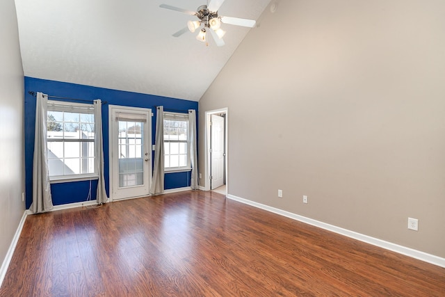 spare room featuring plenty of natural light, baseboards, and wood finished floors