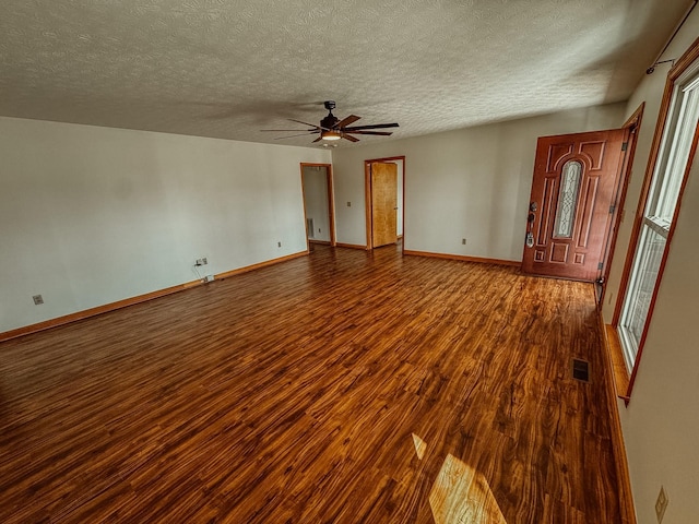 interior space with ceiling fan, visible vents, baseboards, and wood finished floors