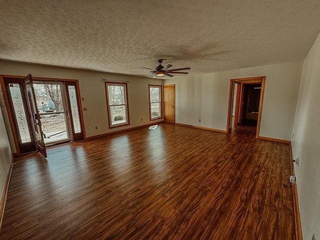 unfurnished room with a textured ceiling, baseboards, and wood finished floors