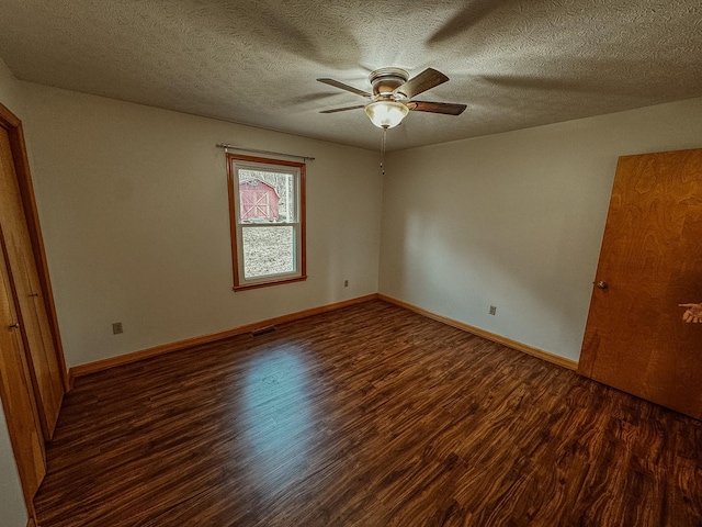 unfurnished bedroom with visible vents, a textured ceiling, baseboards, and wood finished floors