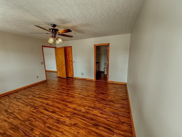 unfurnished room featuring a textured ceiling, baseboards, a ceiling fan, and wood finished floors