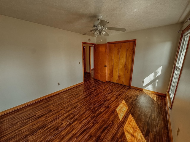 unfurnished bedroom with ceiling fan, wood finished floors, a closet, and baseboards