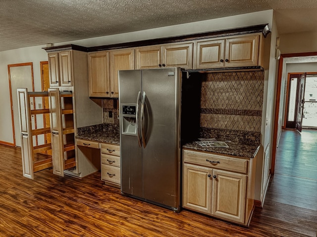 kitchen with dark stone countertops, decorative backsplash, dark wood-type flooring, and stainless steel fridge with ice dispenser