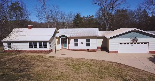 ranch-style house with an attached garage, metal roof, driveway, and a chimney