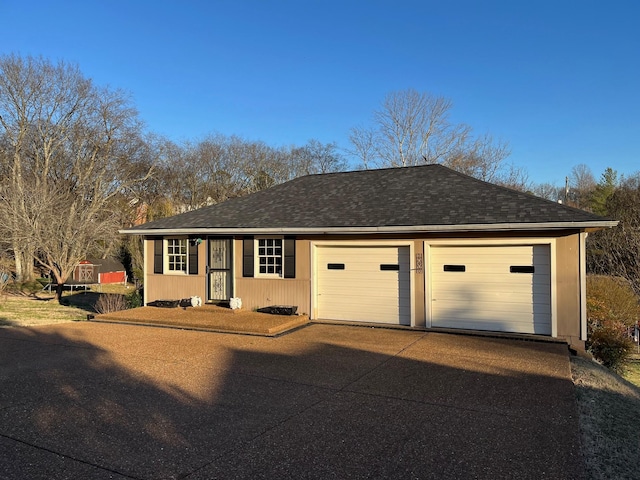 single story home with a garage and a shingled roof