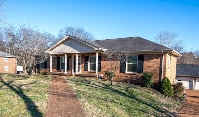 view of front of house with a porch, roof with shingles, a front yard, a garage, and brick siding