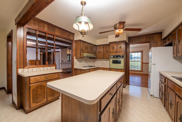 kitchen with under cabinet range hood, white appliances, light countertops, and a ceiling fan