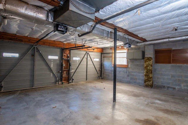 garage featuring concrete block wall and a garage door opener