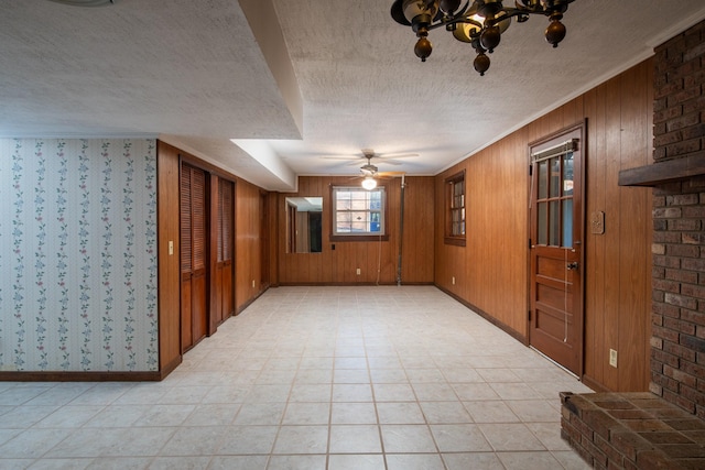 spare room with an inviting chandelier, a textured ceiling, and baseboards