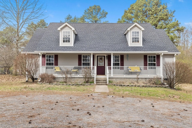 cape cod house featuring covered porch and a shingled roof