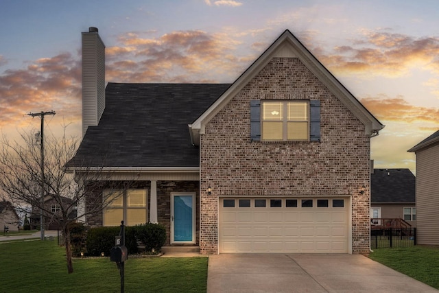 traditional home featuring brick siding, a chimney, an attached garage, driveway, and a front lawn