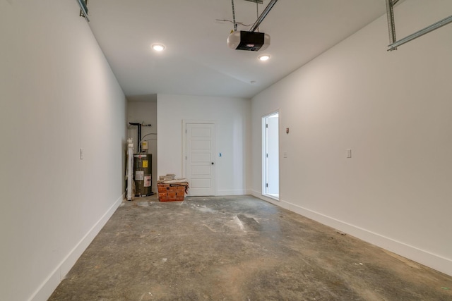 garage featuring baseboards, recessed lighting, electric water heater, and a garage door opener