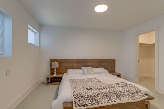 bedroom featuring a spacious closet and baseboards