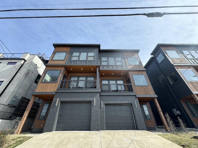 townhome / multi-family property featuring driveway, a balcony, an attached garage, and brick siding