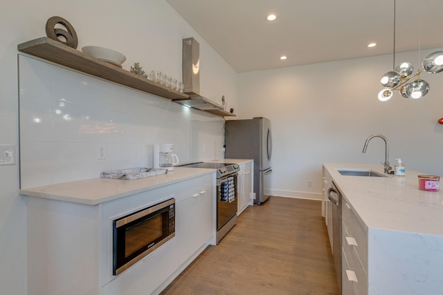 kitchen with open shelves, stainless steel appliances, light wood-style flooring, a sink, and ventilation hood