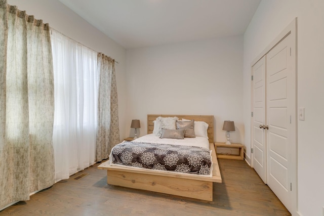 bedroom with visible vents and wood finished floors