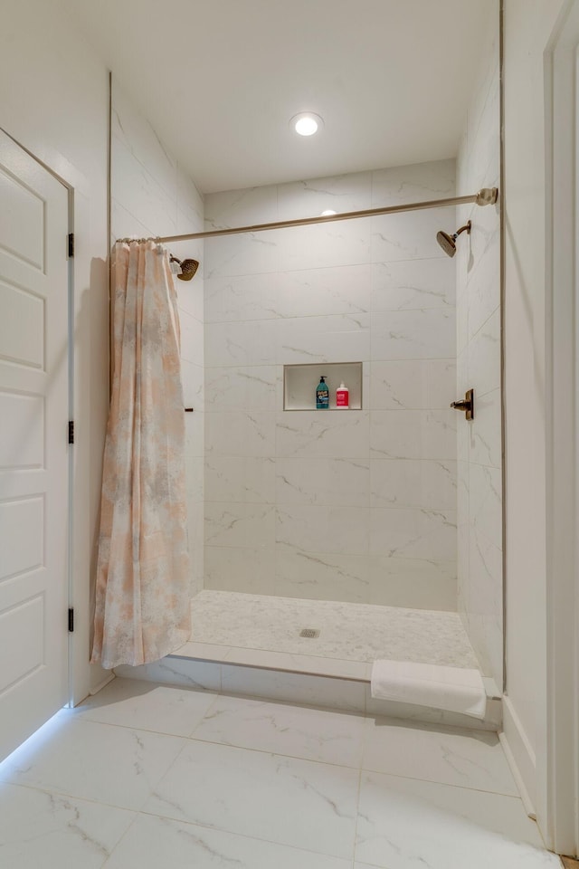 bathroom featuring marble finish floor, a stall shower, and recessed lighting