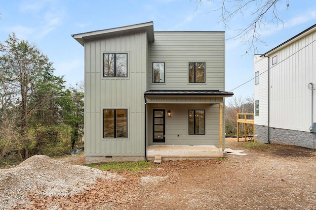 back of property featuring metal roof, crawl space, a standing seam roof, a patio area, and board and batten siding