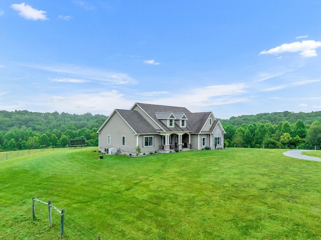 view of front facade featuring a forest view, covered porch, and a front yard