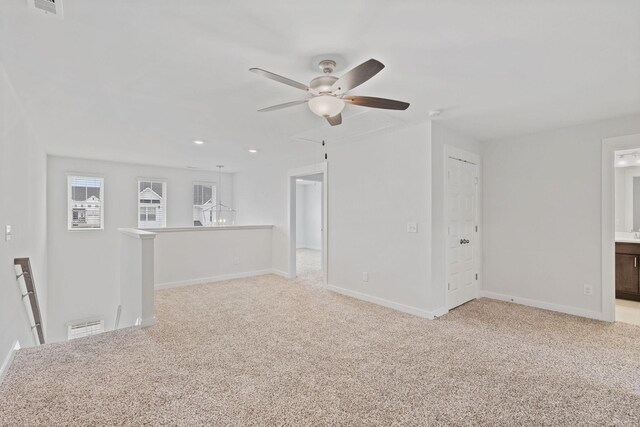 spare room featuring carpet, visible vents, and baseboards