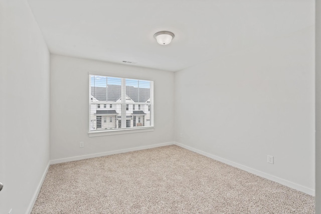 carpeted empty room featuring baseboards