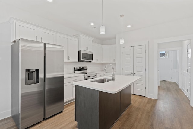 kitchen featuring appliances with stainless steel finishes, light countertops, white cabinetry, and a sink