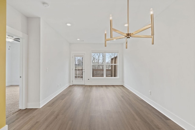 unfurnished living room with baseboards, wood finished floors, and recessed lighting