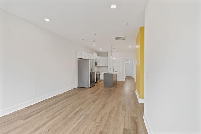 unfurnished living room with light wood-style flooring, visible vents, baseboards, and recessed lighting