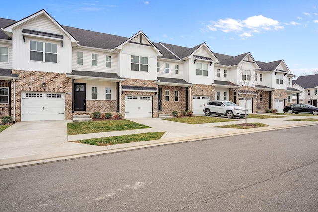 multi unit property featuring an attached garage, brick siding, concrete driveway, a residential view, and board and batten siding