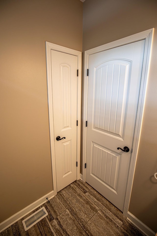 interior space featuring visible vents, baseboards, and wood finished floors