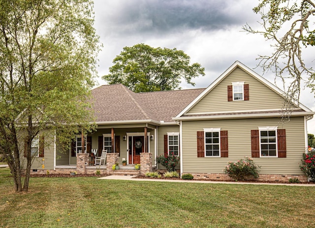 craftsman house with a porch, crawl space, a shingled roof, and a front lawn