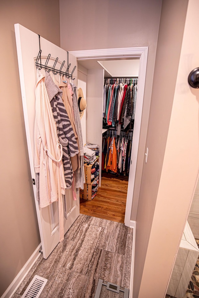 walk in closet featuring visible vents and wood finished floors