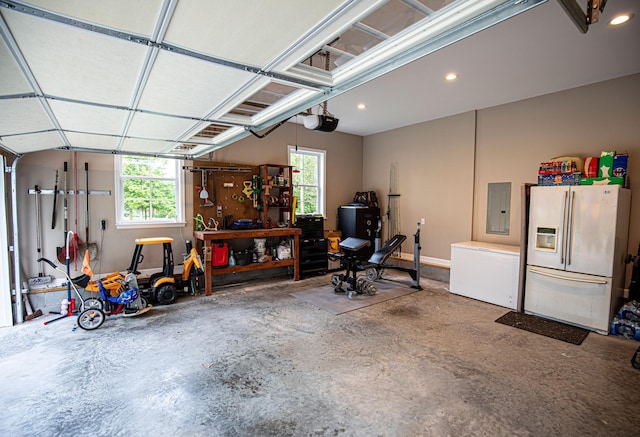 garage featuring electric panel, a garage door opener, fridge, white fridge with ice dispenser, and recessed lighting