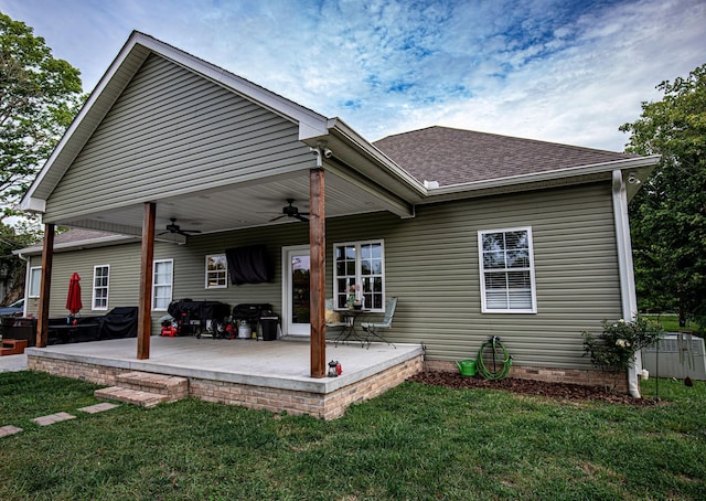 rear view of house featuring a patio, a ceiling fan, roof with shingles, a lawn, and crawl space