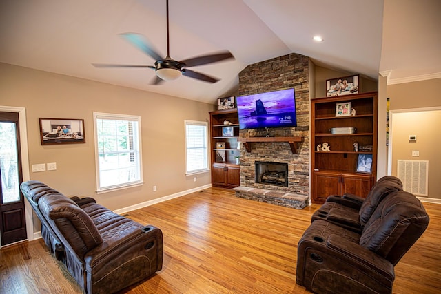 living area with vaulted ceiling, visible vents, a fireplace, and light wood-style flooring