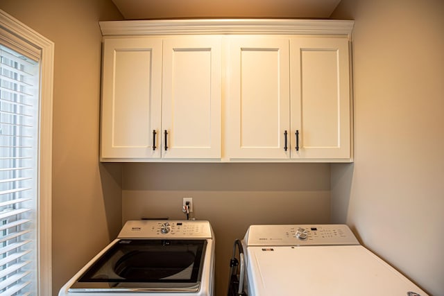 laundry room with washing machine and clothes dryer and cabinet space