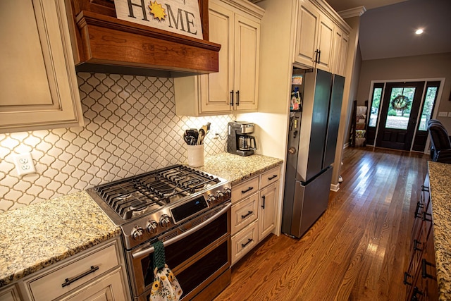 kitchen featuring stainless steel appliances, dark wood-style flooring, custom range hood, and light stone countertops