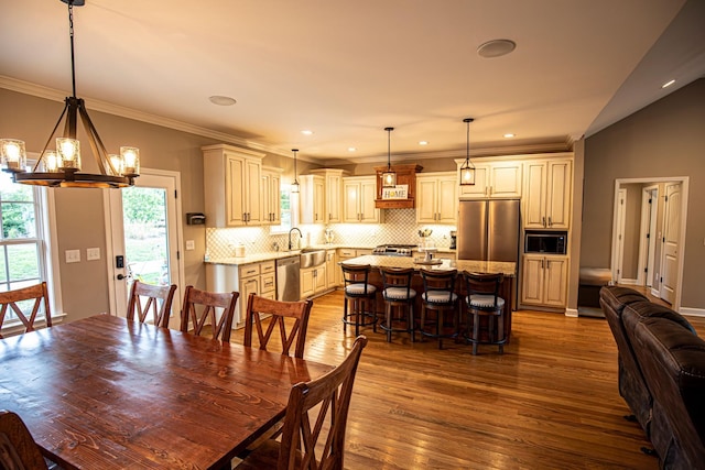 dining area featuring an inviting chandelier, recessed lighting, dark wood-style floors, and ornamental molding