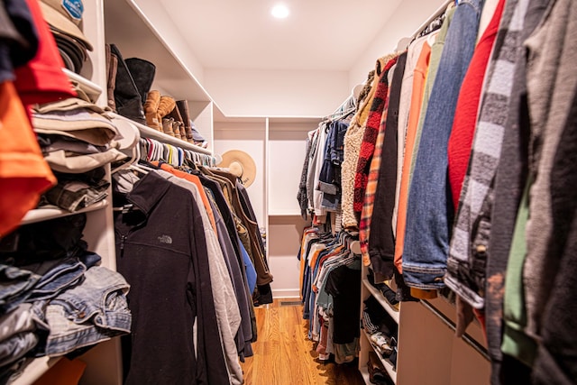 walk in closet with wood finished floors