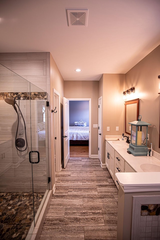 bathroom with double vanity, a stall shower, visible vents, connected bathroom, and wood tiled floor