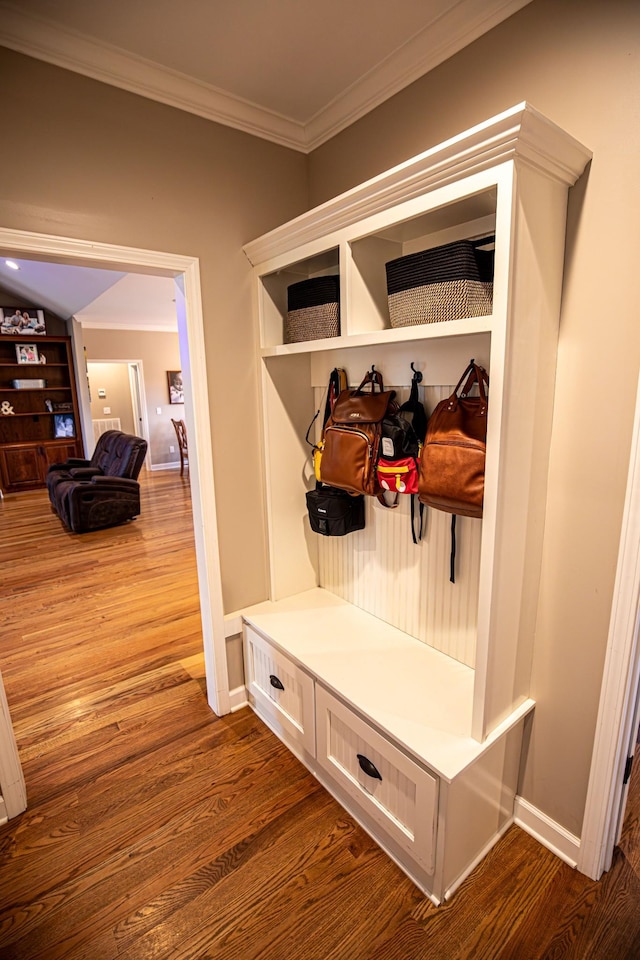 mudroom with crown molding, baseboards, and wood finished floors