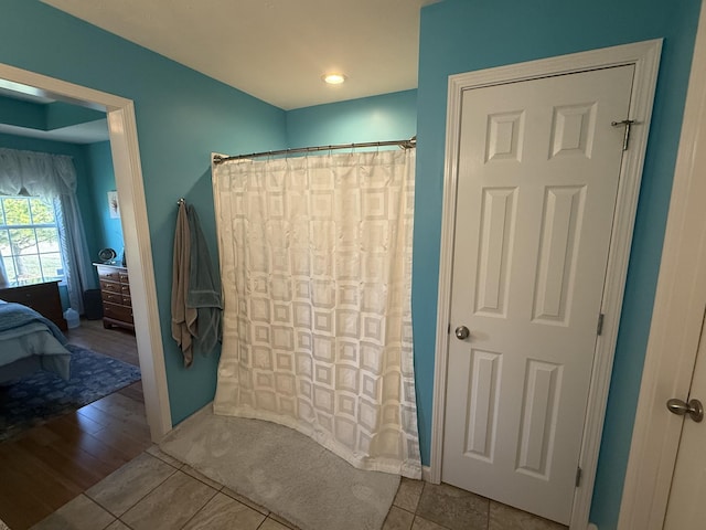 bathroom featuring a shower with curtain and ensuite bath