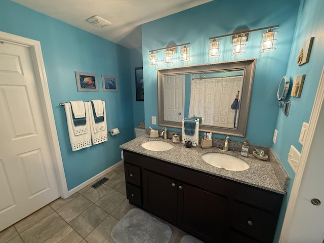 bathroom with tile patterned flooring, visible vents, and a sink