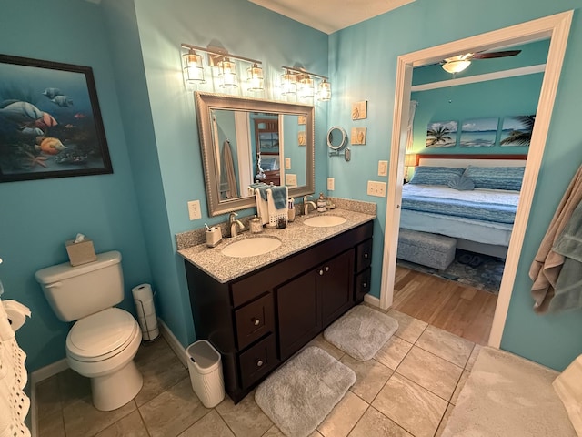 ensuite bathroom with connected bathroom, a sink, toilet, and double vanity